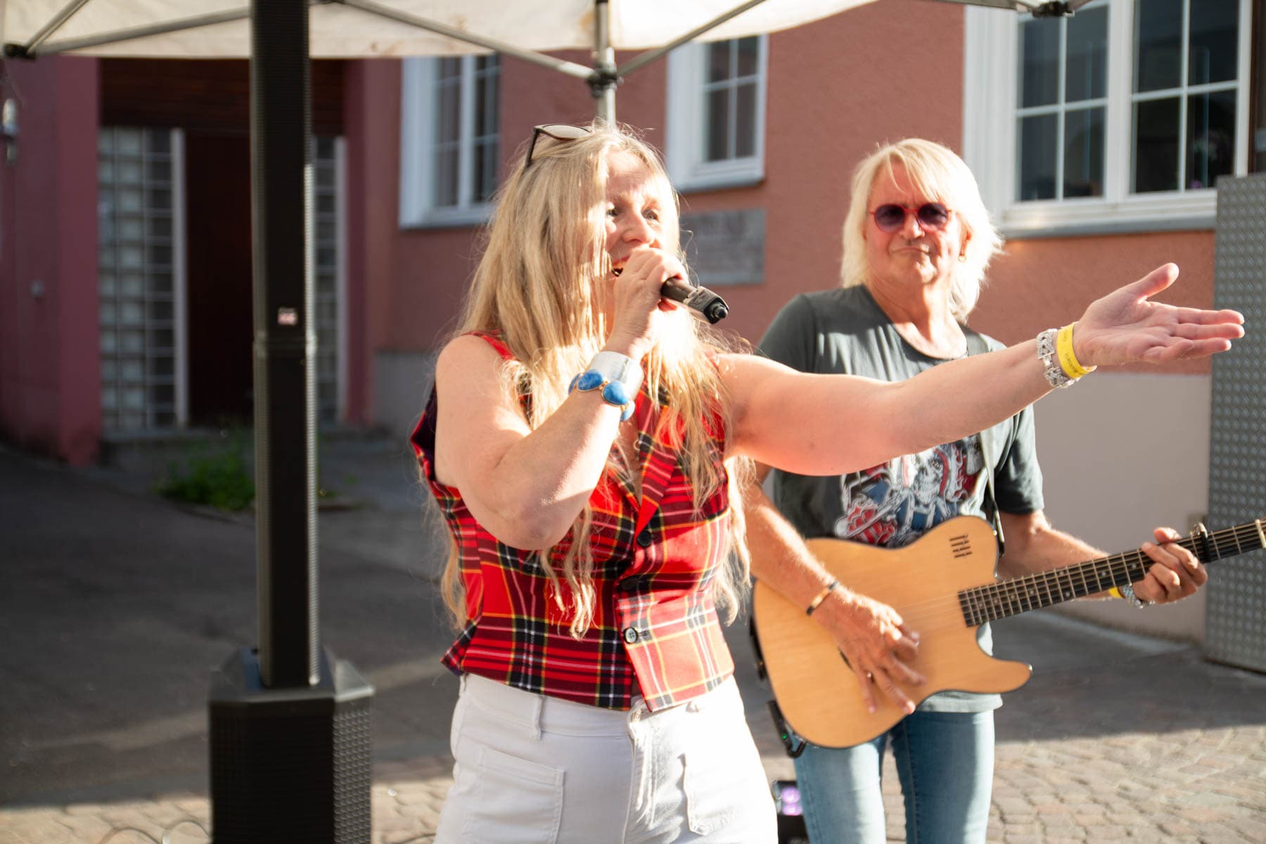 Conny Bains singt bei einem Open-Air-Auftritt, Richy Vogl begleitet sie an der Gitarre